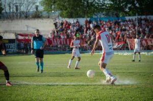 Intense football match showcasing players' skills on a sunny day in Mendoza, Argentina.