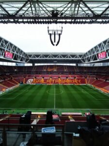 Empty Galatasaray football stadium with green field and empty seats in İstanbul, Türkiye.
